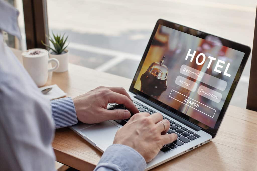 Un professionnel concentré devant son ordinateur portable, effectuant une recherche en ligne sur son bureau.